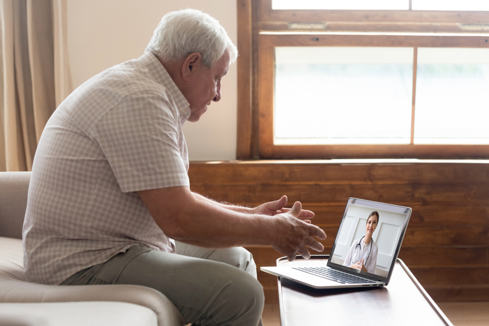 Elderly,70s,Man,Seated,On,Sofa,Make,Distant,Video,Call,