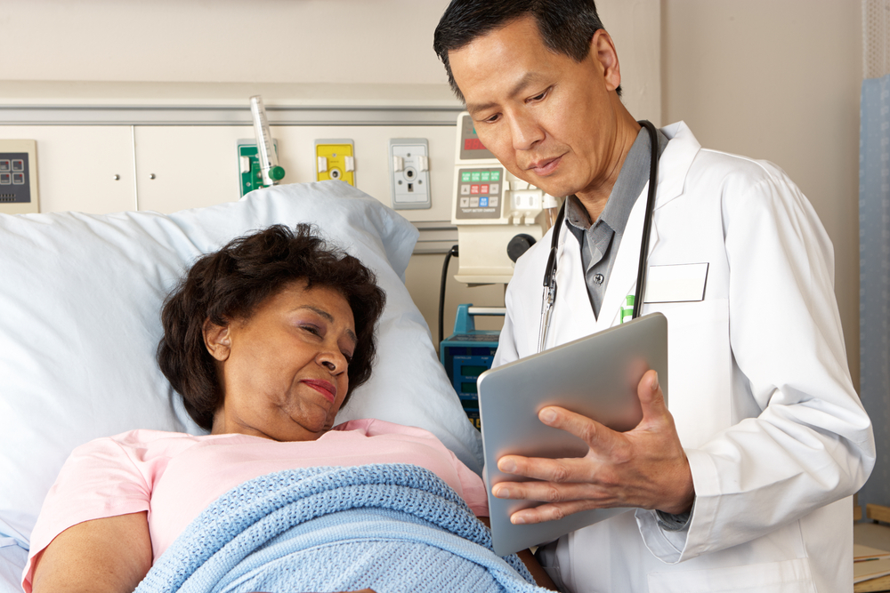 Doctor,Using,Digital,Tablet,Talking,With,Senior,Patient
